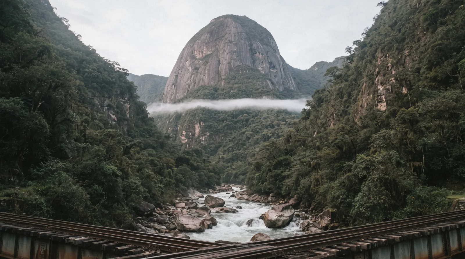 The rounded forested summit of Putucusi Mountain rising above cloud forest beside the Urubamba River, seen from Aguas Calientes