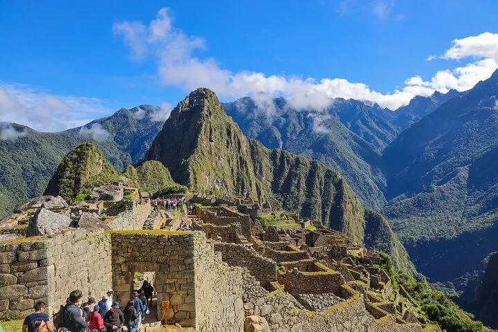 Traveler holding an official Machu Picchu entrance ticket at the citadel gate, Peru