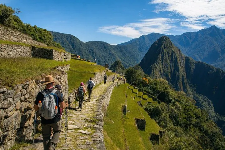Hikers on the 2-day Short Inca Trail approaching the Sun Gate above Machu Picchu, Peru