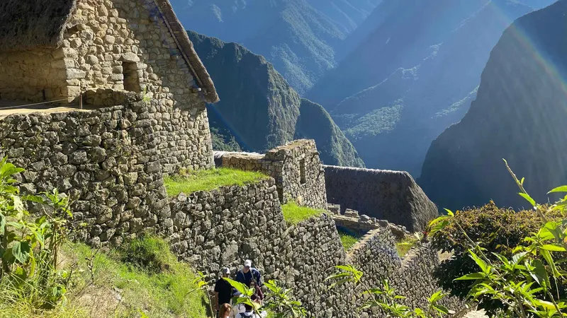 Local guide with a small group of travelers inside the Machu Picchu citadel, Peru